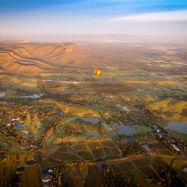 A hot-air ballooon flies over the Hunter Valley