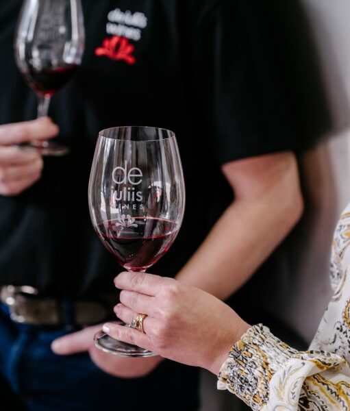Cellar door guests hold at glass of shiraz at the De Iuliis Hunter Valley winery